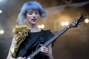 St. Vincent playing her guitar at a live concert.