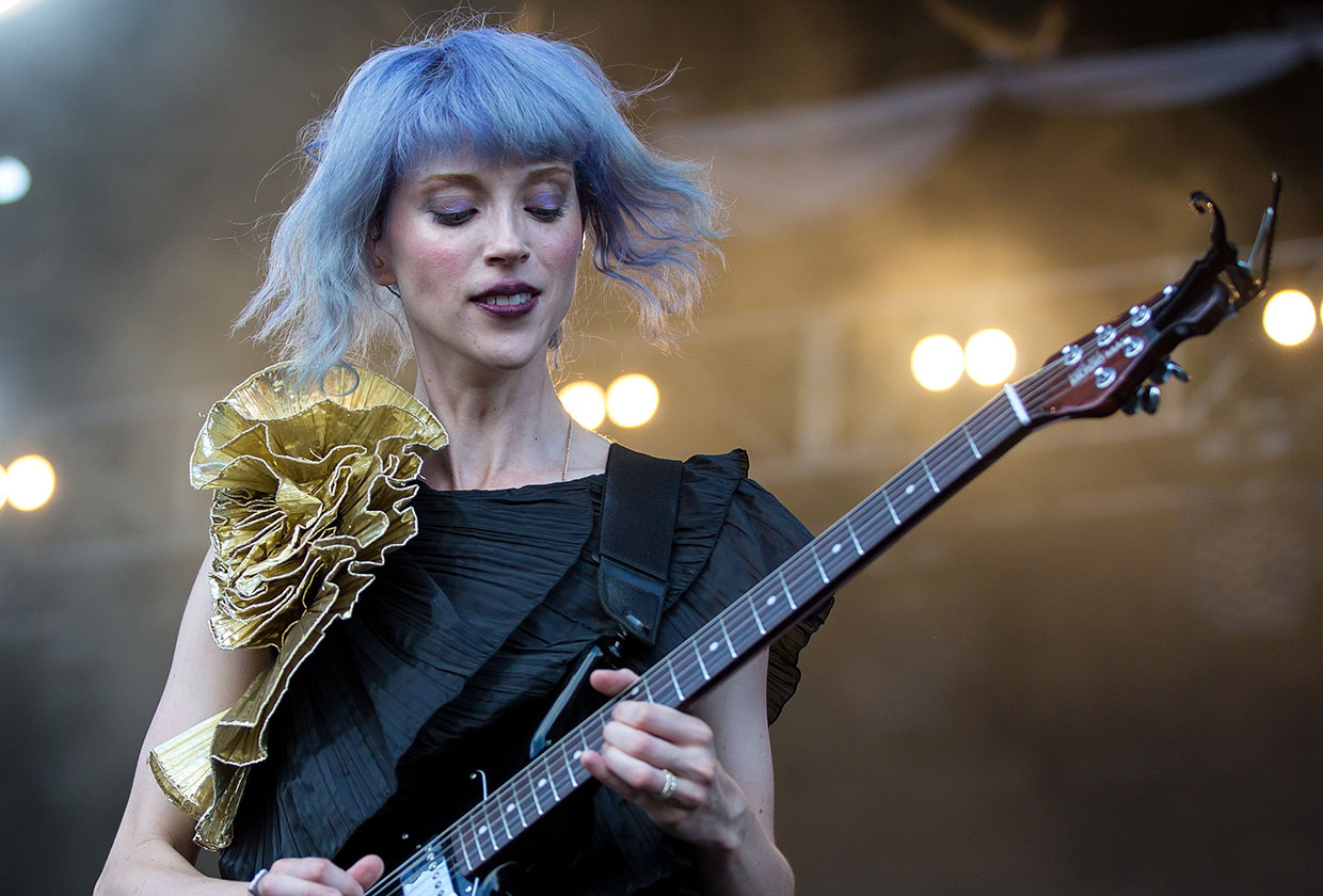 St. Vincent playing her guitar at a live concert.